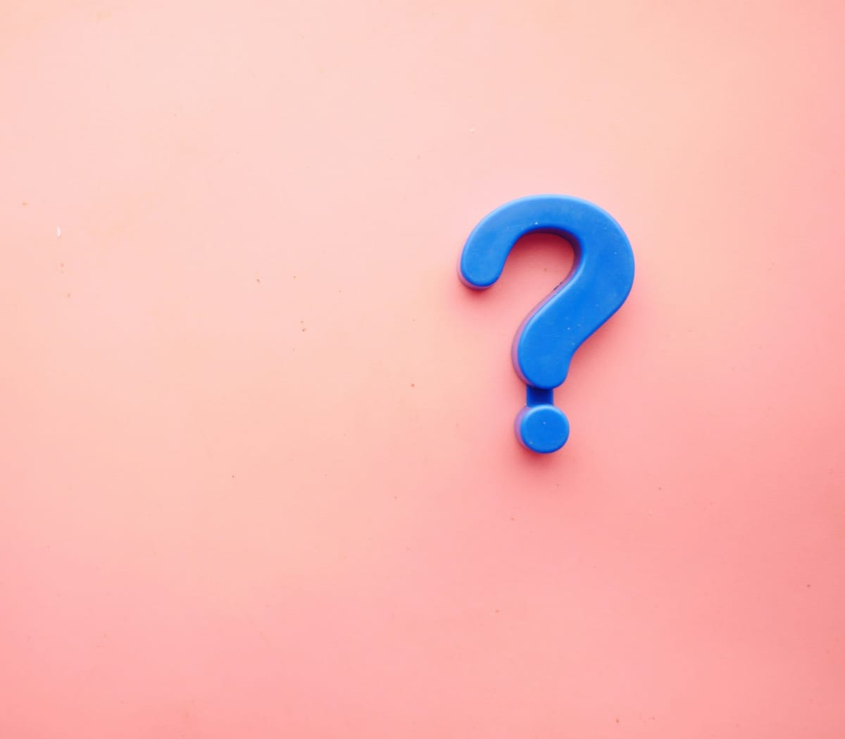 A blue question mark on a pink background