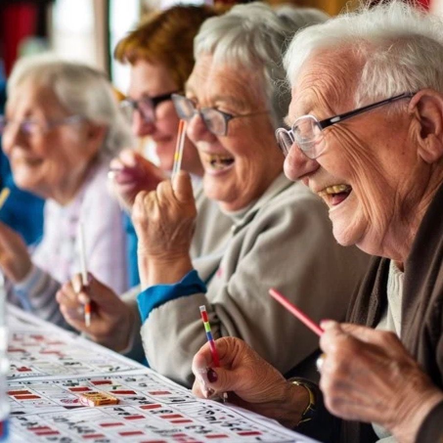 Residents laughing together while playing bingo at a LifeCare Assisted Living home